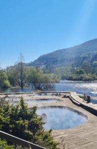 a large pool of water next to a river at CASA JS in Ourense +12 photos
