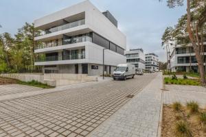 una furgoneta estacionada frente a un edificio en Shellter Premium Apartment Beachside by Renters Prestige, en Rogowo