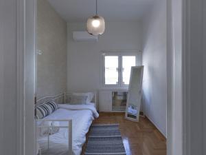 um pequeno quarto com uma cama e uma janela em Beautiful Athenian apartment next to the center em Atenas