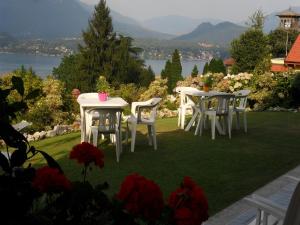 ストレーザにあるB&B Villa la Camanaの湖の景色を望む芝生の上にテーブルと椅子2台