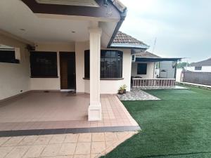 a house with a porch with green grass at Rinting Corner Islamic Homestay, Pasir Gudang in Masai