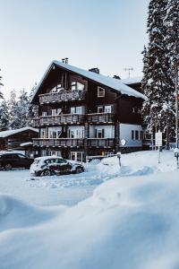 ein schneebedecktes Gebäude mit davor geparkt in der Unterkunft Levin Alppitalot Alpine Chalets in Levi