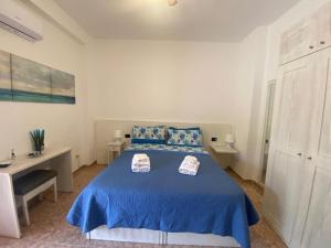 a bedroom with a blue bed and a desk at B&B La Terra di Parmenide in Ascea