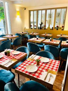 a restaurant with wooden tables and blue chairs at Hotel Douglas in Puteaux