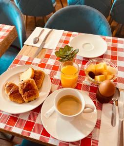 uma mesa com pequeno-almoço de café, croissants e frutas em Hotel Douglas em Puteaux