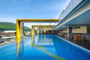 a large swimming pool in a building with a bridge at Grand Artos Hotel & Convention in Magelang