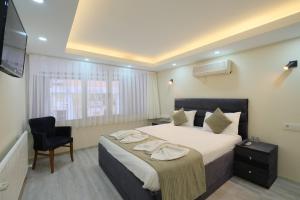 um quarto de hotel com uma cama e uma cadeira em Berlin Hotel Nisantasi em Istambul