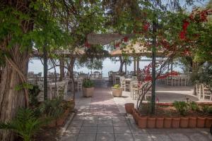 Un patio con mesas y sillas y vista al agua. en Seafront Apartment Grace, en Kalamata