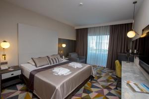een hotelkamer met een bed met handdoeken erop bij Fame Residence Lara & Spa in Lara