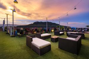 a patio with couches and tables and a view of the ocean at Grand Artos Hotel & Convention in Magelang