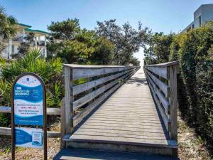 a wooden bridge with a sign in front of it at Bungalows at Seagrove #149 - Three Little Birds Bungalow 30A in Seagrove Beach