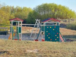 two playground equipment in a field with a slide at Jūras dzintars in Ainaži