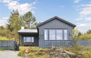 a gray house with a bench in front of it at Amazing Home In Kopervik With Wifi And 3 Bedrooms in Kopervik