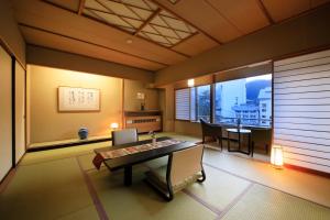 ein Zimmer mit einem Tisch und einem Esszimmer mit einem Fenster in der Unterkunft Naruko Fuga in Osaki