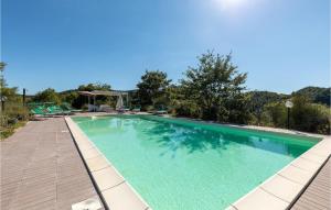 a large swimming pool with a wooden walkway around it at La Casa Di Valcerosa in Apecchio