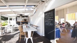 Un restaurante con una mesa y una pizarra en la pared. en Avani - Modern & Tranquil - Wifi, en Booker Bay 3 fotos más