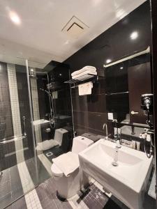 Hotel Aman Kuala Lumpur في كوالالمبور: حمام مع مرحاض ومغسلة ودش