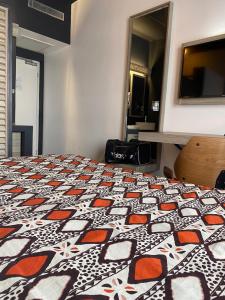 1 dormitorio con 1 cama con edredón estampado en ONOMO Hotel Lomé en Lomé