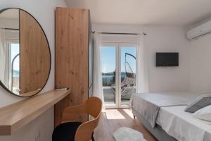 1 dormitorio con espejo, cama y ventana en Villa Kuzmanić, en Trogir