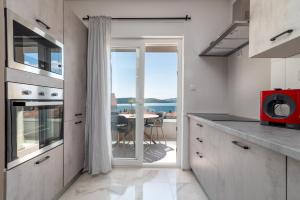 a kitchen with a table with a view of the ocean at Villa Kuzmanić in Trogir