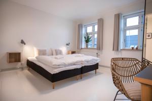 1 dormitorio con 1 cama grande y 2 ventanas en Skovsgård Hotel en Brovst