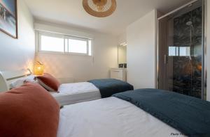 - une chambre avec 2 lits et une fenêtre dans l'établissement Superbe T3 de 70m2 face à la mer, à Royan