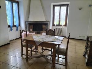 une salle à manger avec une table, des chaises et une cheminée dans l'établissement Rod Ranch Livestock - Appartamento con camino e vista piscina, à Campagnano di Roma