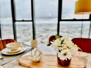 uma mesa com um vaso de flores brancas em High rise top view 2bed2bath em Melbourne
