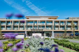 an office building with flowers in front of it at Deltapark Vitalresort**** in Thun