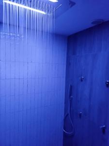 baño con ducha con luz azul en Domus Bama, en Ceglie Messapica