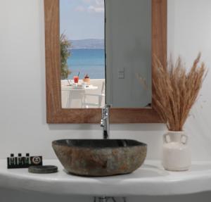 um lavatório de casa de banho com um espelho e um lavatório de pedra em Ippokampos Beachfront em Naxos Chora mais 37 fotografias