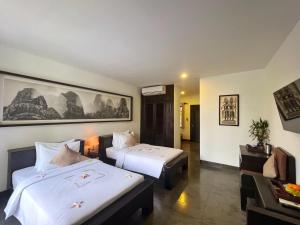 a hotel room with two beds and a couch at The Bliss Angkor in Siem Reap