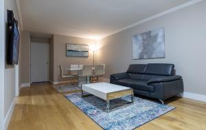 uma sala de estar com um sofá e uma mesa em Lovely 3 BR in NYC with Elevator em Nova York