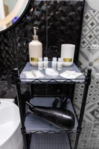 a black shelf with a blow dryer on it in a bathroom at Lena Suite Bari Vecchia in Bari