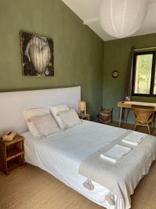 una camera da letto con un grande letto bianco e pareti verdi di Cévennes - Sublime chambre d'hôtes indépendante et moderne a Monoblet