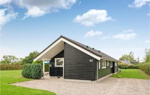 uma pequena casa preta com telhado em Beautiful Home In Slagelse With Kitchen em Venemose