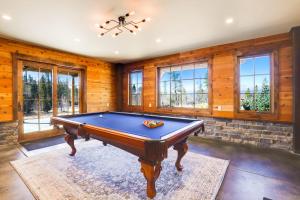 un tavolo da biliardo in una stanza con pareti e finestre in legno di The McQueen Haus ad Alma