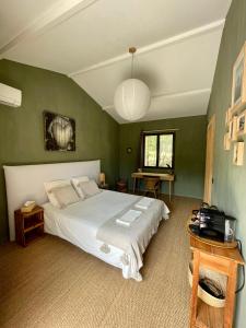 1 dormitorio con 1 cama grande y paredes verdes en Cévennes - Sublime chambre d'hôtes indépendante et moderne, en Monoblet