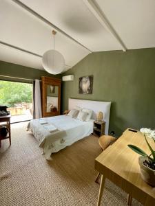 ein Schlafzimmer mit einem großen Bett und einem Tisch in der Unterkunft Cévennes - Sublime chambre d'hôtes indépendante et moderne in Monoblet