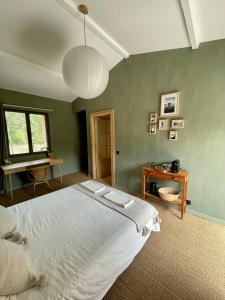 ein Schlafzimmer mit einem großen weißen Bett und einem Tisch in der Unterkunft Cévennes - Sublime chambre d'hôtes indépendante et moderne in Monoblet