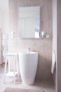 Chic Appart - Sauna privatif في توركوان: حمام مع حوض أبيض كبير ومغسلة