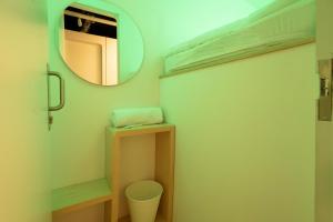 La salle de bains est pourvue d'un miroir et de toilettes. dans l'établissement Bobopod Tanah Abang, Jakarta, à Jakarta