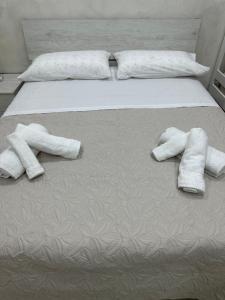 uma cama com duas toalhas brancas em ChloeHouse em Nápoles