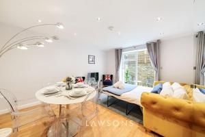 uma sala de estar com uma mesa e um sofá em Stylish Living by Lawsons with 3 Ensuites em Windsor