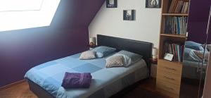 a bedroom with a blue bed with pillows on it at Belle Longère in Campeaux