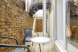 a table and chairs on a balcony with a window at Crowning Around I Parking in Windsor