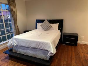 a bedroom with a large bed with white sheets and a window at Thula Guest Farm in Clarens