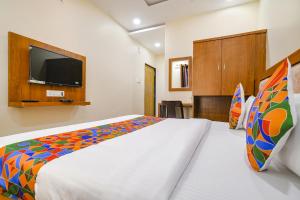 a bedroom with a bed and a flat screen tv at FabHotel Atharv in Indore