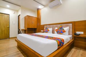 1 dormitorio con 1 cama grande en una habitación en FabHotel Atharv, en Indore