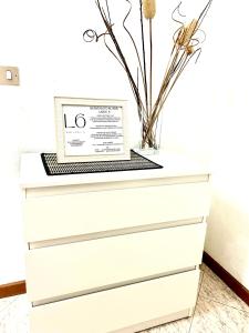 a white dresser with a vase on top of it at SM Hospitality LAGHI in Reggio Emilia